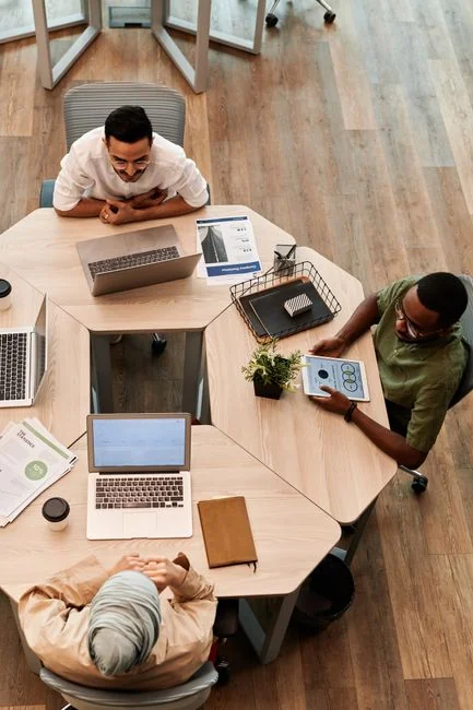 Overhead view of a diverse team collaborating on a project in a modern office setting.